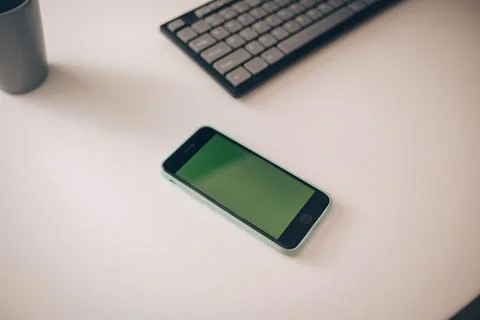 Mobile with a green screen, the smartphone is on the table near the clarifier Stock Photos