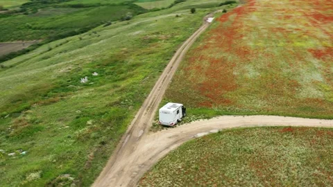 The mobile home is located in a field of red poppies. Camper. Motorhome Vidéo 157447744