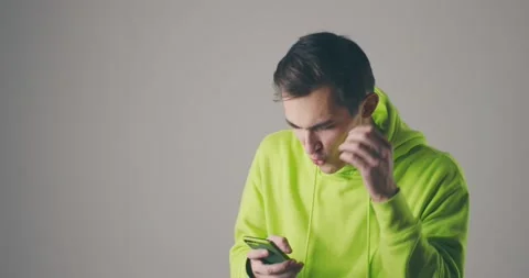 Mobile internet usage. Surprised guy in scrolling pictures on social networks Stock Footage 147691562