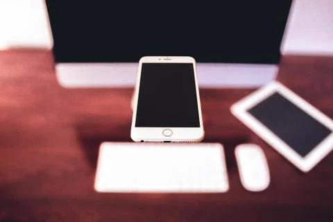 Mobile levitating against unfocused background with desktop computer Stock Photos