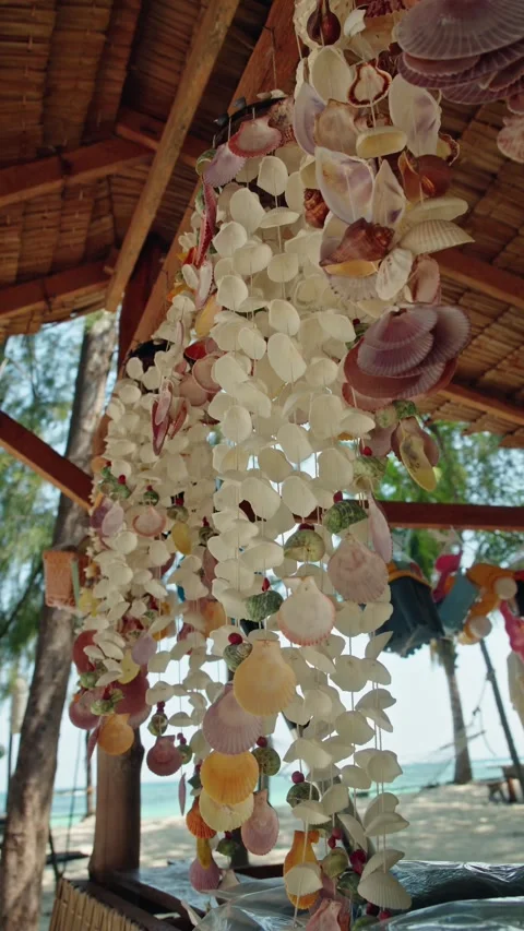 Mobile made of seashells hanging and gently swaying in tropical breeze on s.. Vidéo 334906181