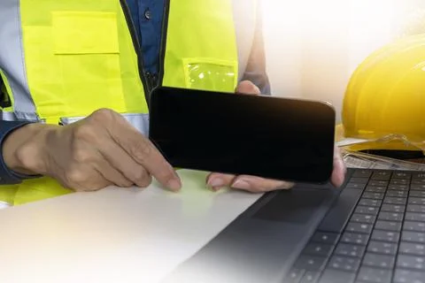 A mobile mockup where an engineer holds up a screen to insert graphics or tex Stock Photos