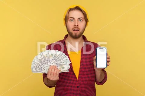 Mobile money transfer, online banking. Surprised hipster guy in checkered shi Stock-Fotos
