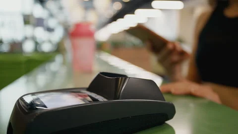 Mobile NFC payment for order in gym cafe. Hand of woman customer paying through Video stock 130853931