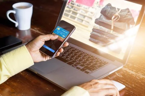 Mobile payments, Man using smartphone for online shopping on laptop screen Fotos Stock