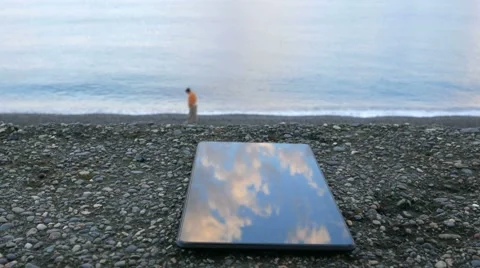 The mobile phone is about the pebble beach of the ocean. Calm waves beating Stock Footage 67616190