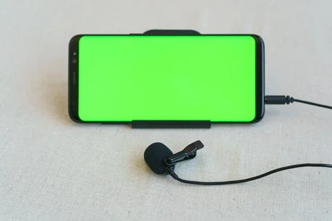 Mobile phone and microphone on table Stock Photos