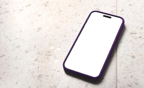 Mobile phone with a blank white screen lies diagonally on a terrazzo tile s.. Stock Photos