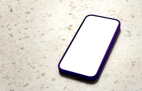 Mobile phone with a blank white screen lies vertically on a light terrazzo .. Stock Photos
