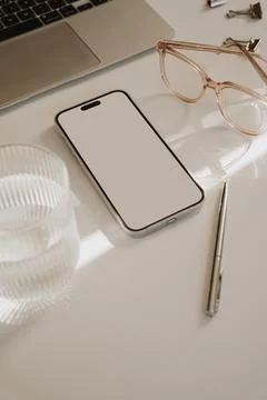 Mobile phone with blank white screen, laptop computer, decanter and glass of  Stock Photos
