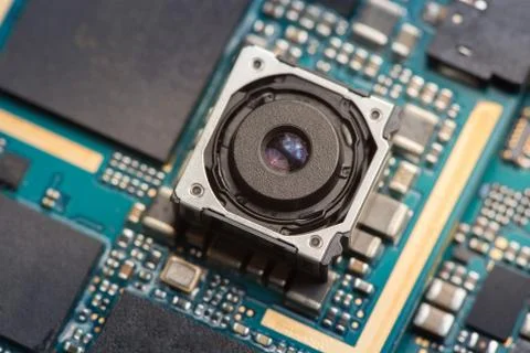 Mobile phone camera module on a blue printed circuit board. Stock Photos