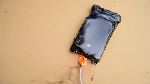 Mobile phone caught fire from wire, recharging from electrical network in socket Stock Footage 277269394