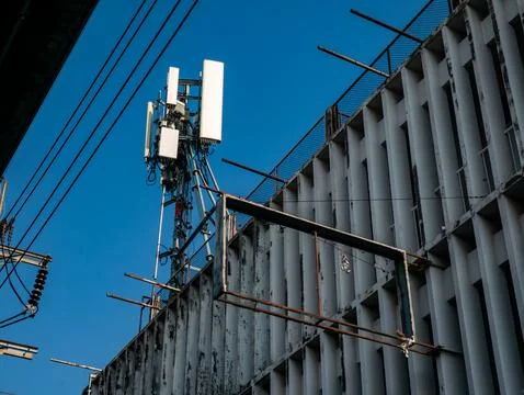 Mobile phone cell tower with multiple antennas and equipment mounted on a r.. Foto stock