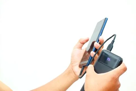 Mobile phone charging using power bank with a display showing 99% charge le.. Stock Photos