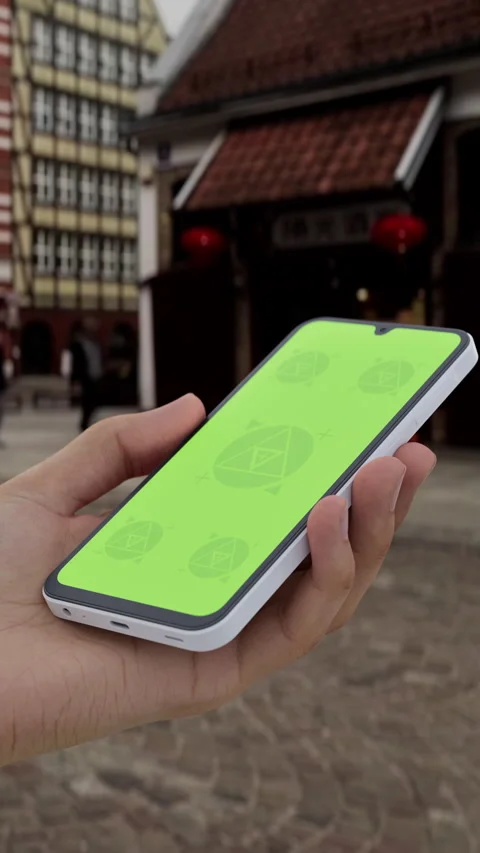 Mobile phone with customizable screen held in hand in a lively urban plaza Stock Footage 296943613