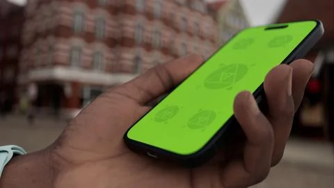 Mobile phone with customizable screen held in hand in a lively urban plaza Stock Photos