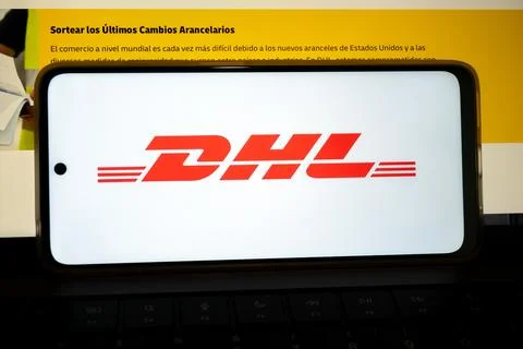 Mobile phone displaying dhl logo on a keyboard Fotos de archivo