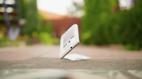 Mobile phone falls and breaks on the concrete ground in slow motion Video stock 119024643