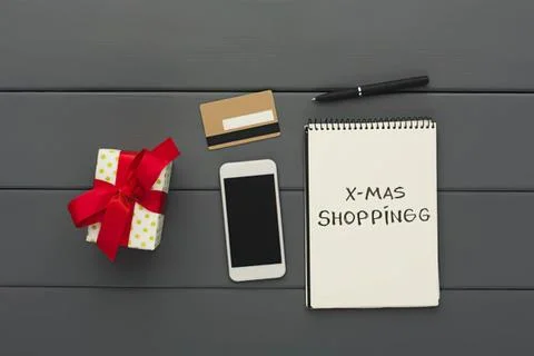 Mobile phone, gift, notepad, and pen on gray surface Stock Photos
