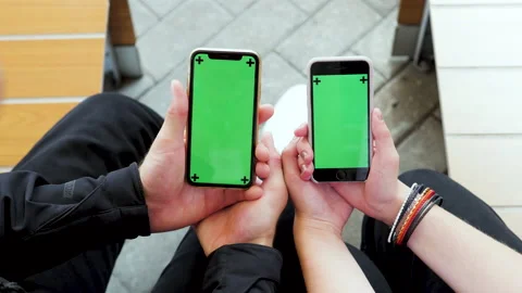 Mobile phone with a green screen in the hands of a girl and a guy. chroma key Stock Footage 174306717