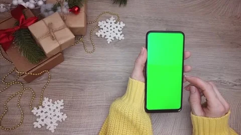 A mobile phone with a green screen in the hands of a woman in close-up, top view Stock Footage 292154997