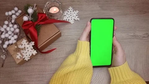 A mobile phone with a green screen in the hands of a woman and swipe across the Stock Footage 294094991
