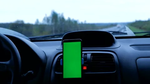 Mobile phone with a green screen inside a car parked on the road Stock Footage 165409675