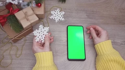 A mobile phone with a green screen in the right hand in close-up, in the left Stock Footage 295068549