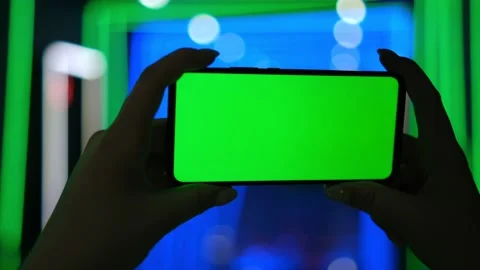Mobile phone in hand. Holding smartphone with red blue neon lighting on dark Stock Footage 237604053
