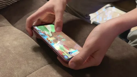 Mobile phone in the hands of a child. Application with kids games on the screen  Stock Footage 237718847