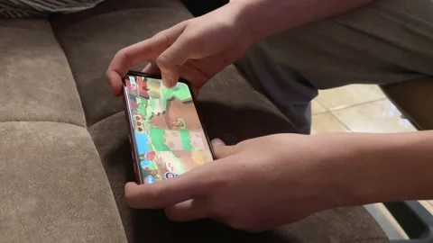 Mobile phone in the hands of a child. Application with kids games on the screen  Stock Footage 237718852