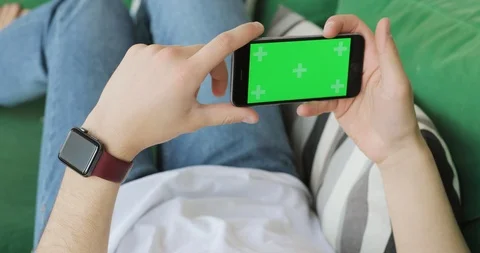 Mobile phone with horizontal green screen in man's hands. Stock Footage 108020064