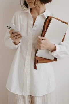 Mobile phone, laptop computer and office documents in female hands. Young pre Stock Photos