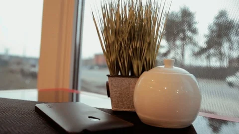 Mobile phone lying on the coffee table. View at the street through window Stock-Footage 104732017