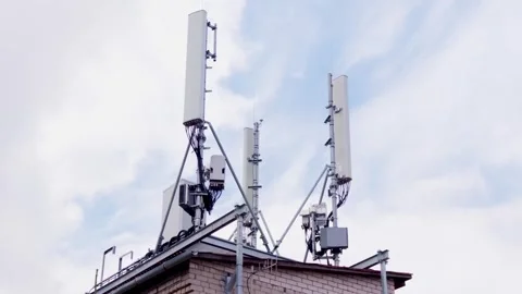 Mobile phone mast telecommunication tower antennas on building top in Stock Footage 343733993