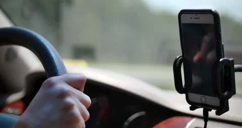 Mobile phone mounted to a stand on a dashboard in a car Stock Footage 152487904