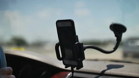 Mobile phone mounted in a stand to the windscreen of a car Stock Footage 152487519