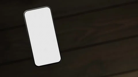 The mobile phone is slightly raised above the wooden table, showing the scree Stock Footage 261365824
