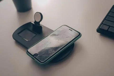 The mobile phone is on the table. Smartphone with broken screen, glass. Scree Stock Photos