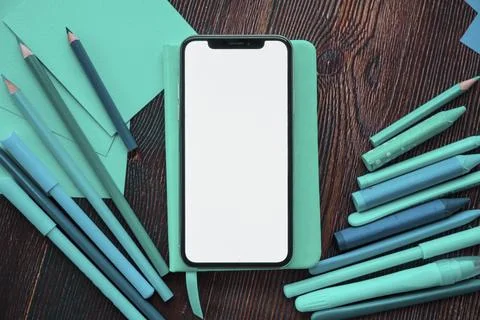 Mobile phone with white screen diary near painting colors wooden table Stock Photos