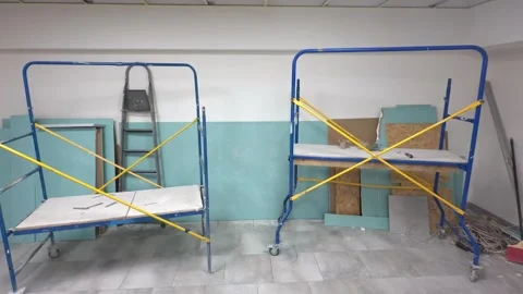 Mobile scaffold towers with platform and stepladder at a site with drywall .. Stock Footage 340549786