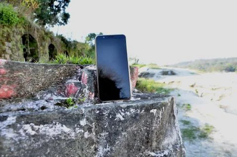 Mobile Set on Wall Besides River Amb India 1 Stock Photos