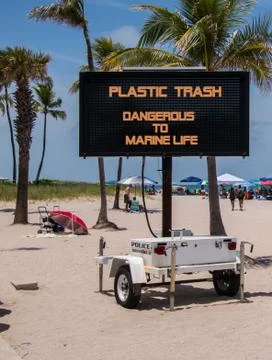 Mobile sign on beach warning that plastic is dangerous to marine life Stock Photos
