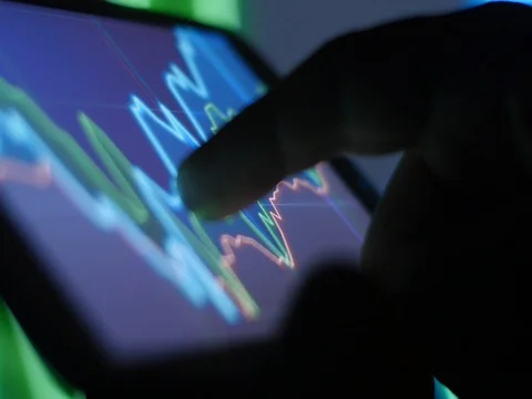 Mobile smart phone device trading in shares and stocks Stock Footage 73944024