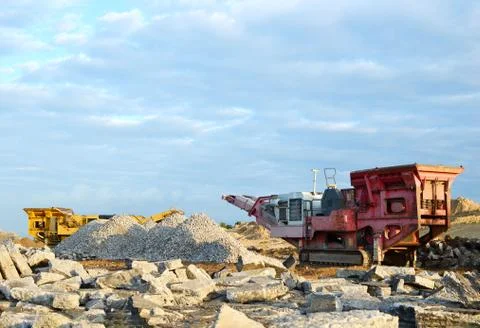 Mobile Stone crusher machine by the construction site or mining quarry Stock Photos