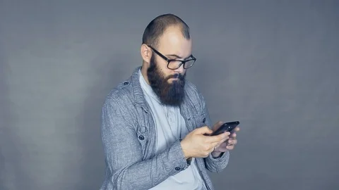 Mobile technology and digital device addiction. smiling man holding phone. Stock Footage 104262593