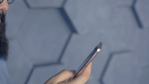 Mobile technology and digital device addiction. smiling man holding phone. Video stock 105322174