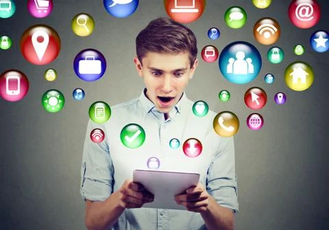 Mobile technology high tech concept. Amazed man using tablet computer with so Stock Photos