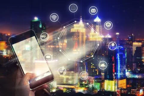 Mobile with wireless communication network and night city background. E-comme Stock Photos