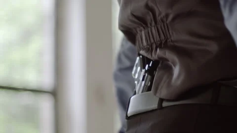Mobster quickly pulls gun from belt behind back, close-up Video stock 156367504